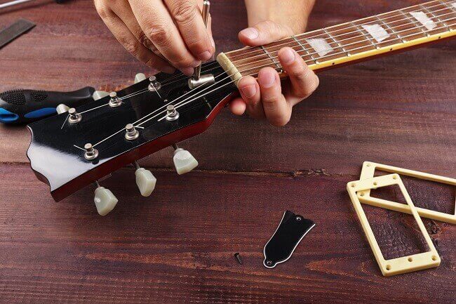 adjusting a truss rod on a guitar